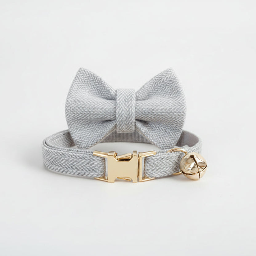 ​Collier nœud papillon gris élégant pour chat en cuir synthétique avec boucle dorée et clochette - Palais Félin Paris.
