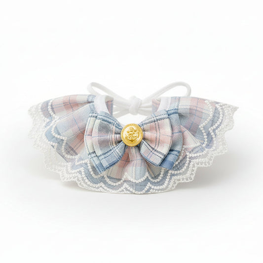 ​Collier d'exception pour chat en tissu bleu saphir, orné d'un petit nœud papillon artisanal, d'une perle de nacre et de détails dorés - Palais Félin Paris.