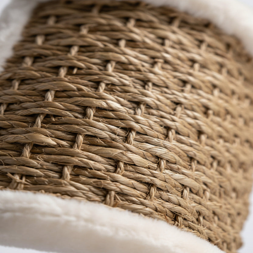 ​Gros plan détaillé sur le tissage artisanal en jonc de mer naturel d'un griffoir pour chat, texture résistante et élégante, Palais Félin Paris.